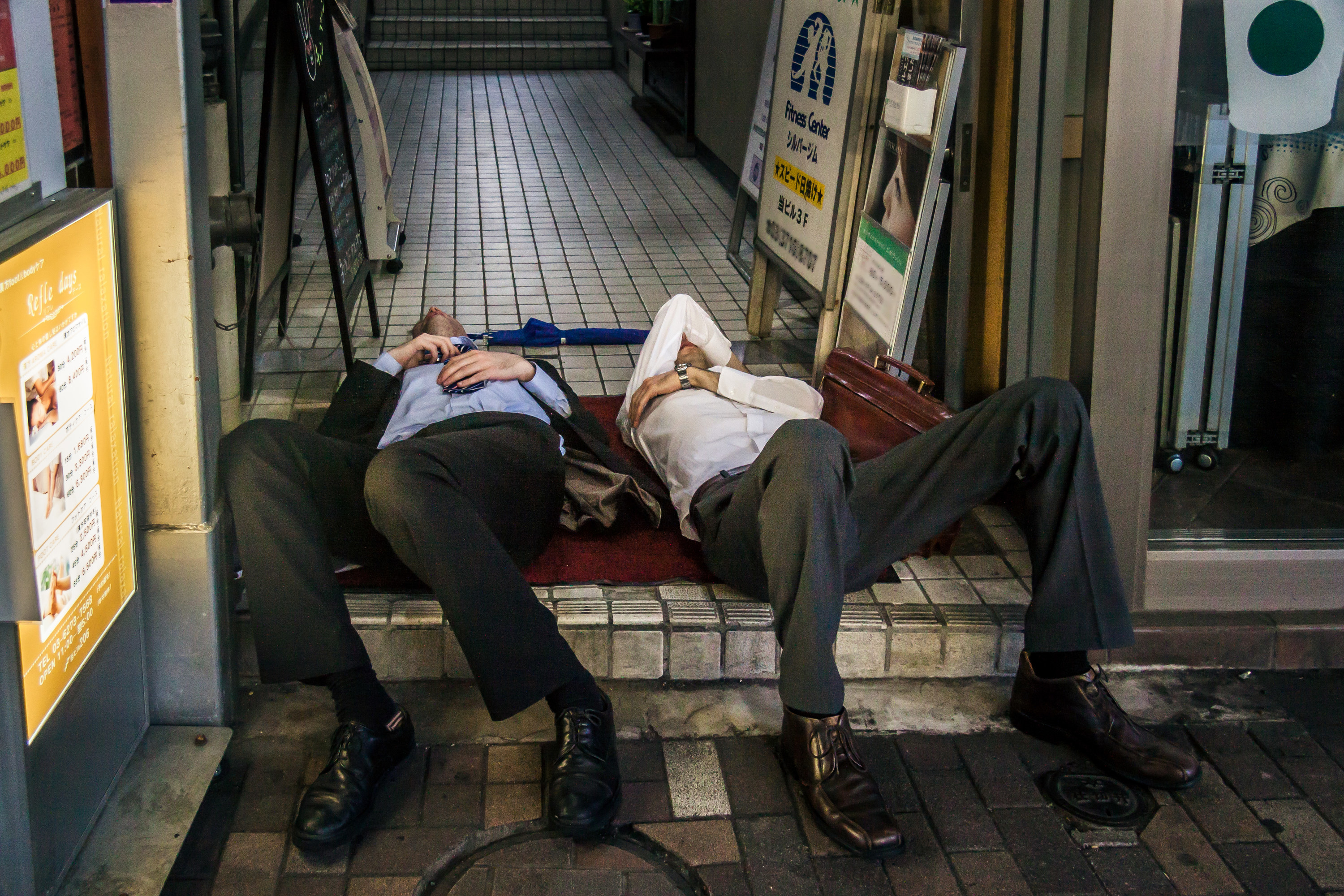 Two men in suits passed out on the street