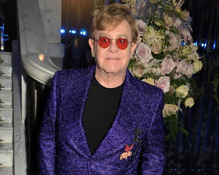 Elton wears a sparkly purple suit jacket