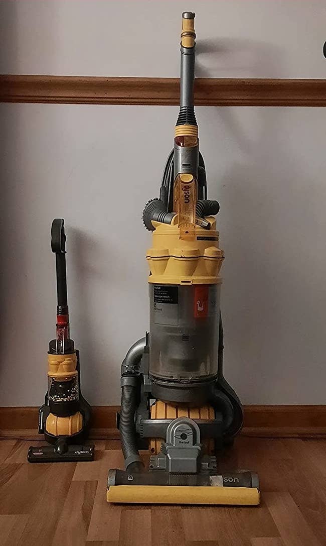 tiny vacuum toy next to the vacuum is designed after