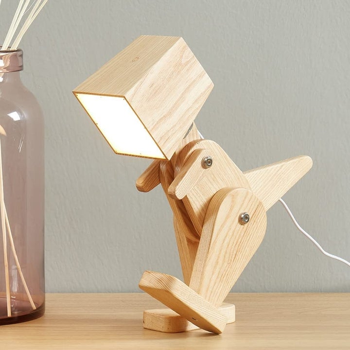 the light wooden dinosaur lamp on a desk