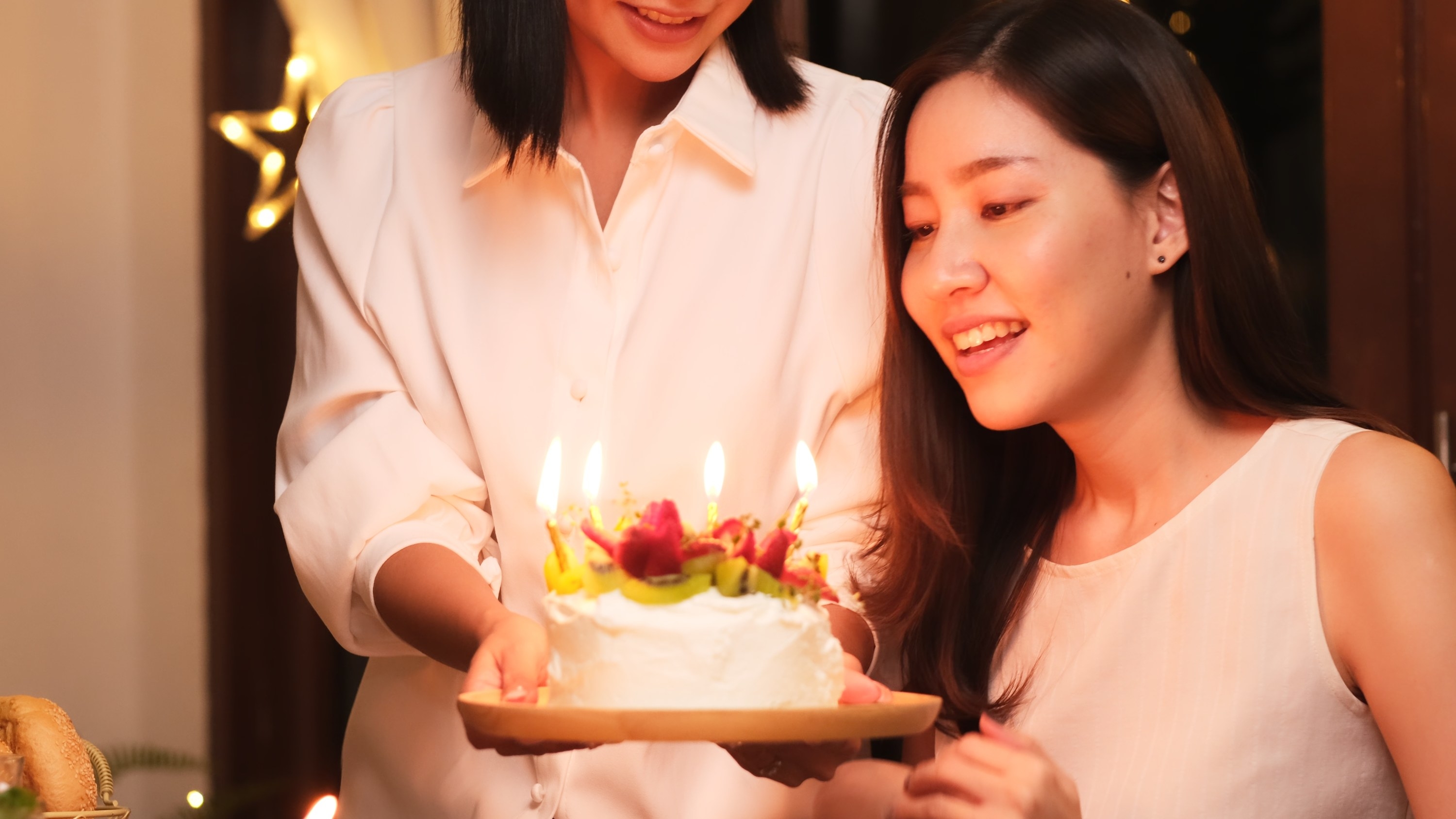 A girl blowing out candles on a birthday cake