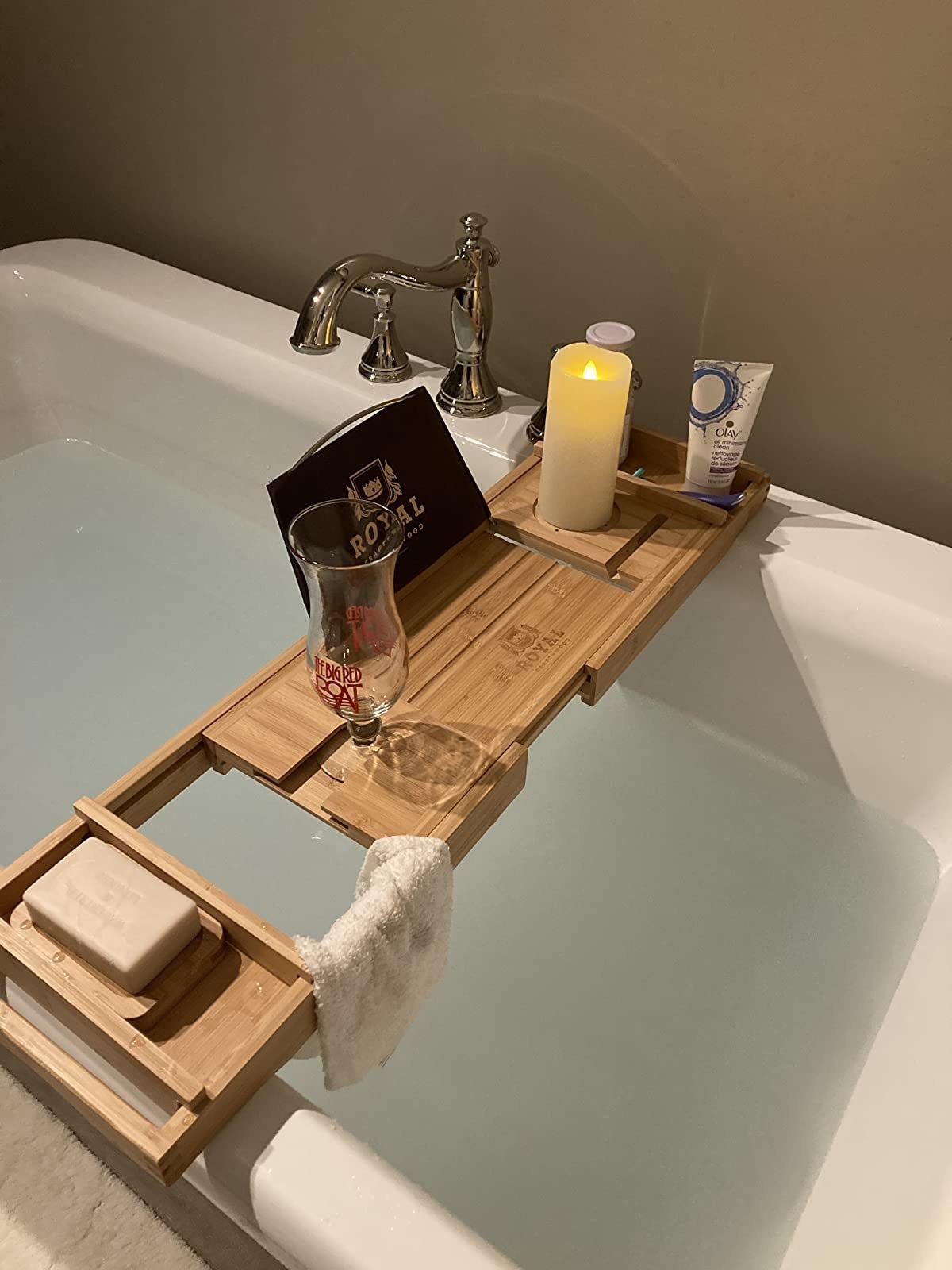 A bamboo tray sitting on top of a bathtub filled with water