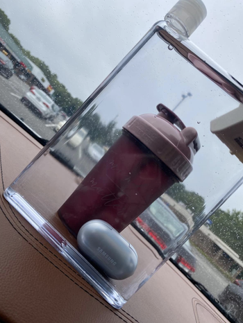 reviewer image of the clear, flat water bottle in front of a regular water bottle