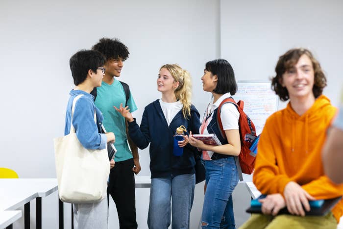 A group of college students gather to chat after class