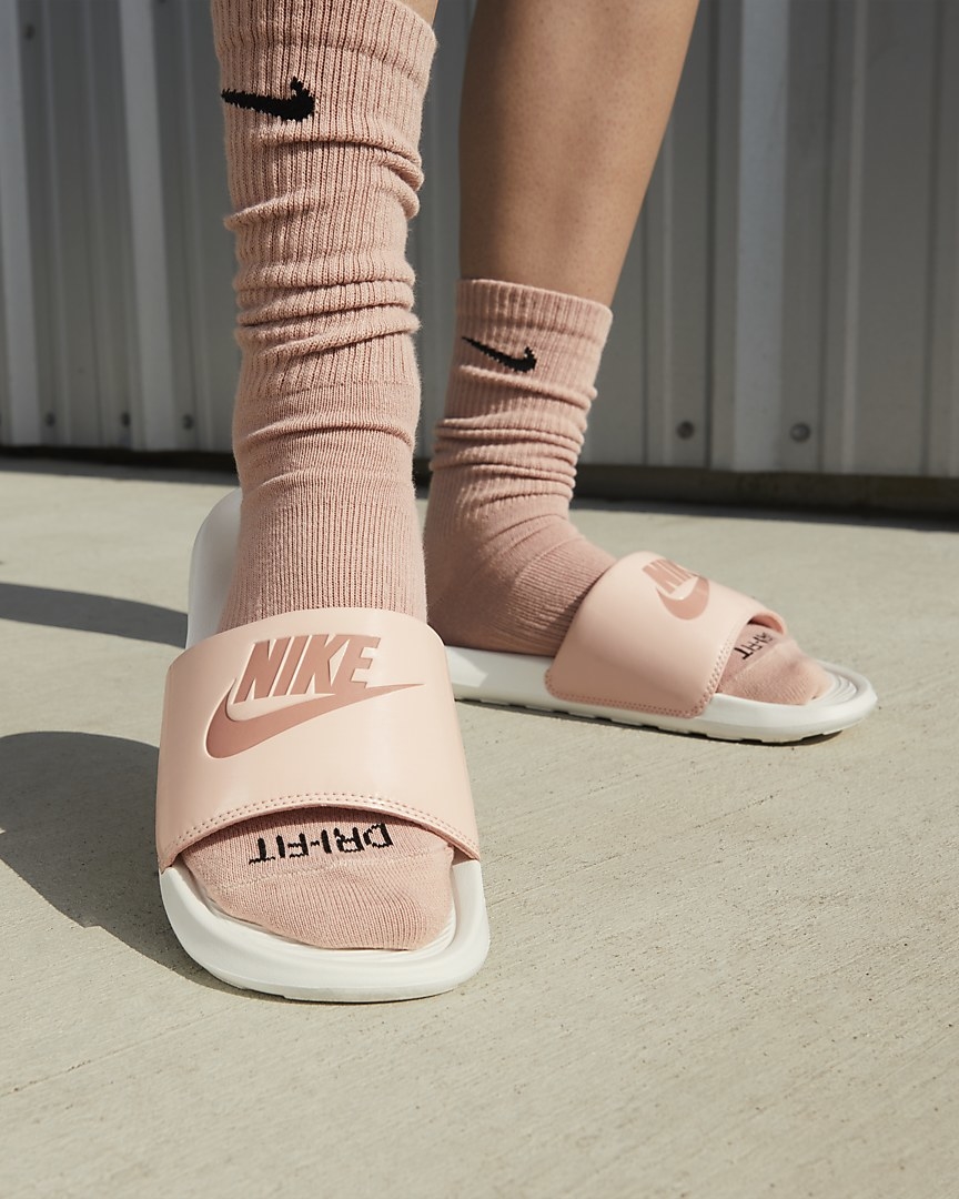 Model wearing pink and white slides