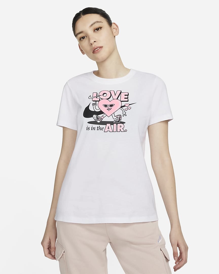 Model wearing white tee that says &quot;love is in the air&quot;