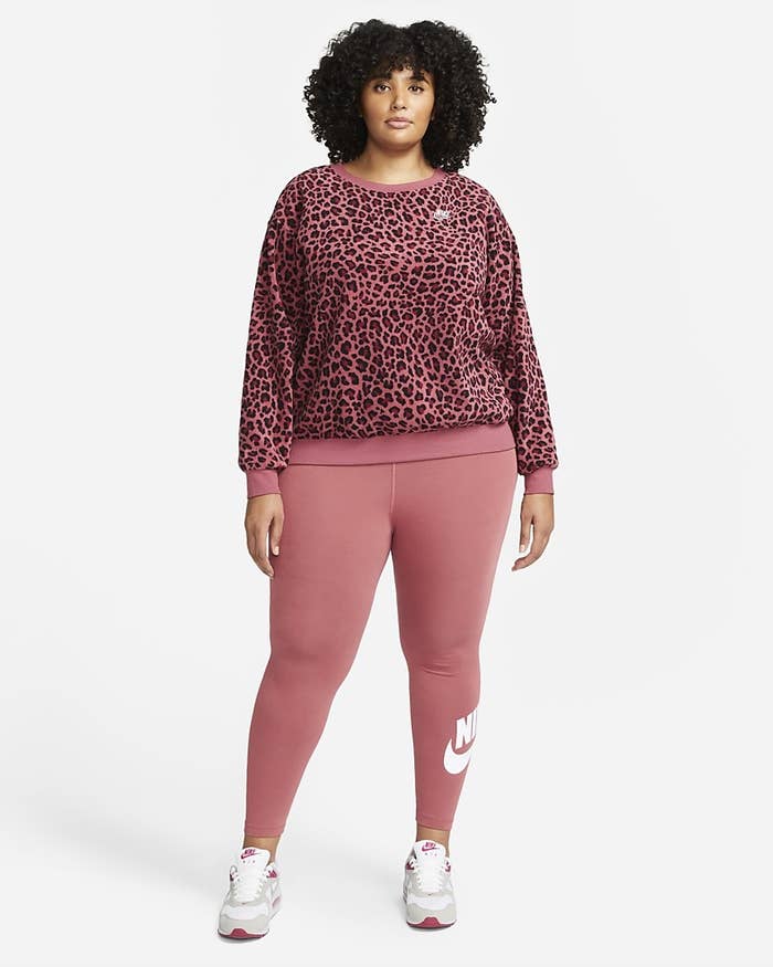 Model wearing fleece with pink leggings and white sneakers