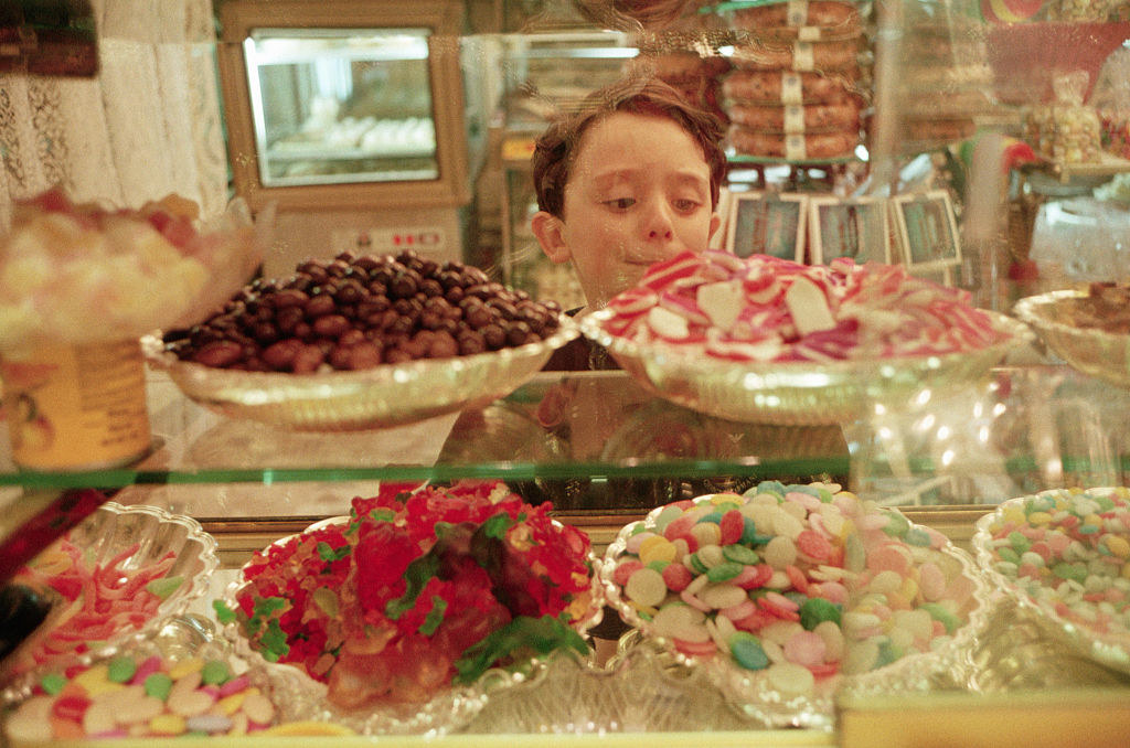 Kid looking at bowls of candy