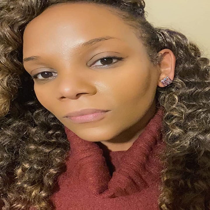 reviewer wearing the multicolored earrings