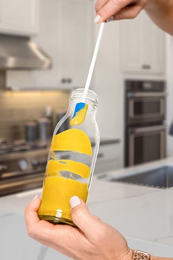 a model using a small spatula to get mustard out of jar