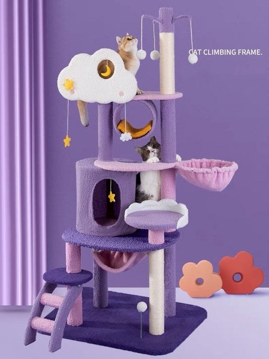 A purple, pink, white, and yellow cat tree with a starry moonlight theme and multiple cats playing in it