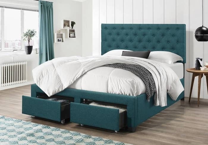 teal upholstered bed frame with drawers pulled out