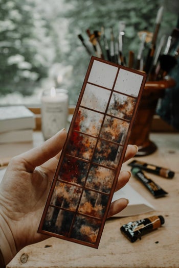 bookmark with autumnal trees through a window in the rain