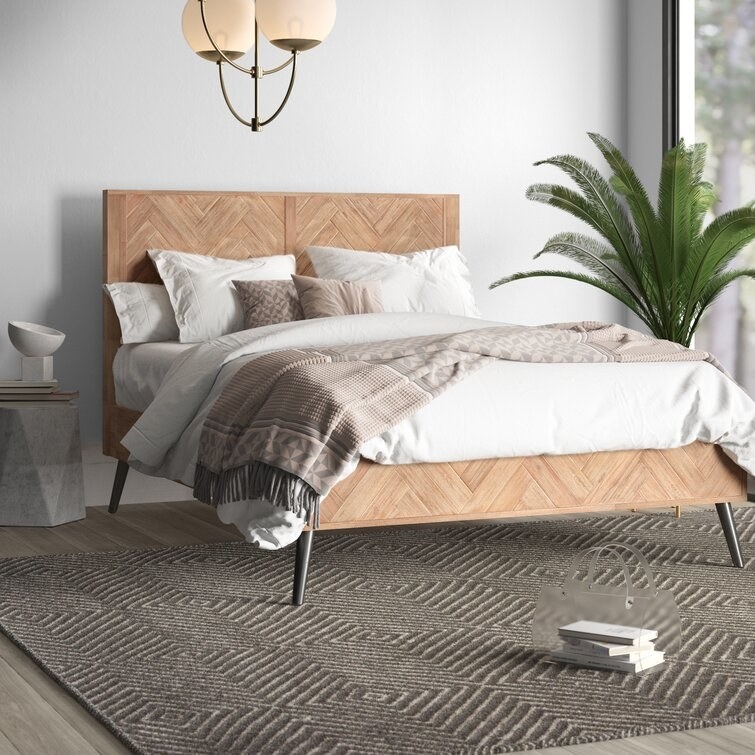 herringbone wooden bed frame staged in a bedroom
