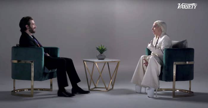 Gaga and Jake sit in chairs opposite each other while speaking