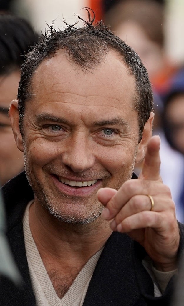 Jude Law pointing at someone in acknowledgement during an event