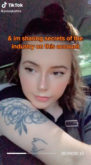 Karlie showing off her arm tattoo while answering questions about working in porn