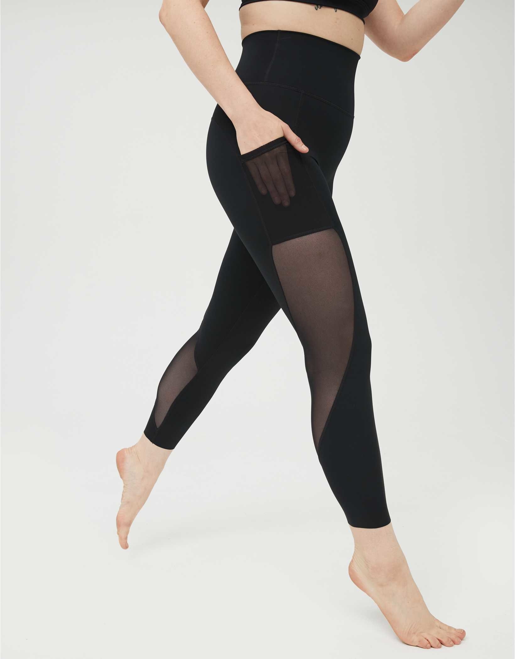 Model in black leggings with pockets and mesh paneling on the sides