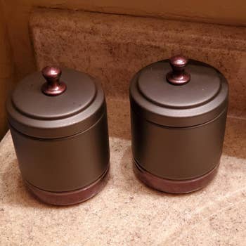 a reviewer photo of a pair of bronze-colored jars with lids