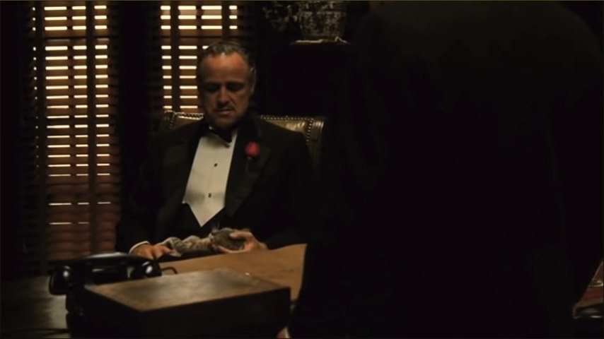 Vito sitting behind his desk holding a cat in &quot;The Godfather&quot;