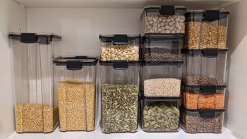 a reviewer photo of the different sized containers filled with dry goods on a shelf