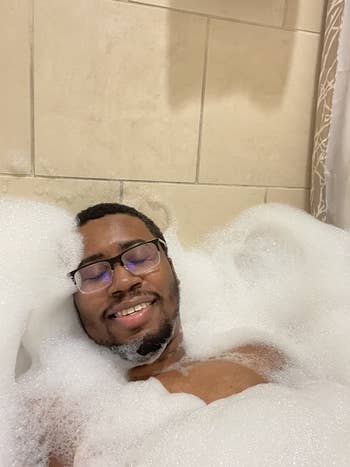 reviewer surrounded by bubbles enjoying a bath