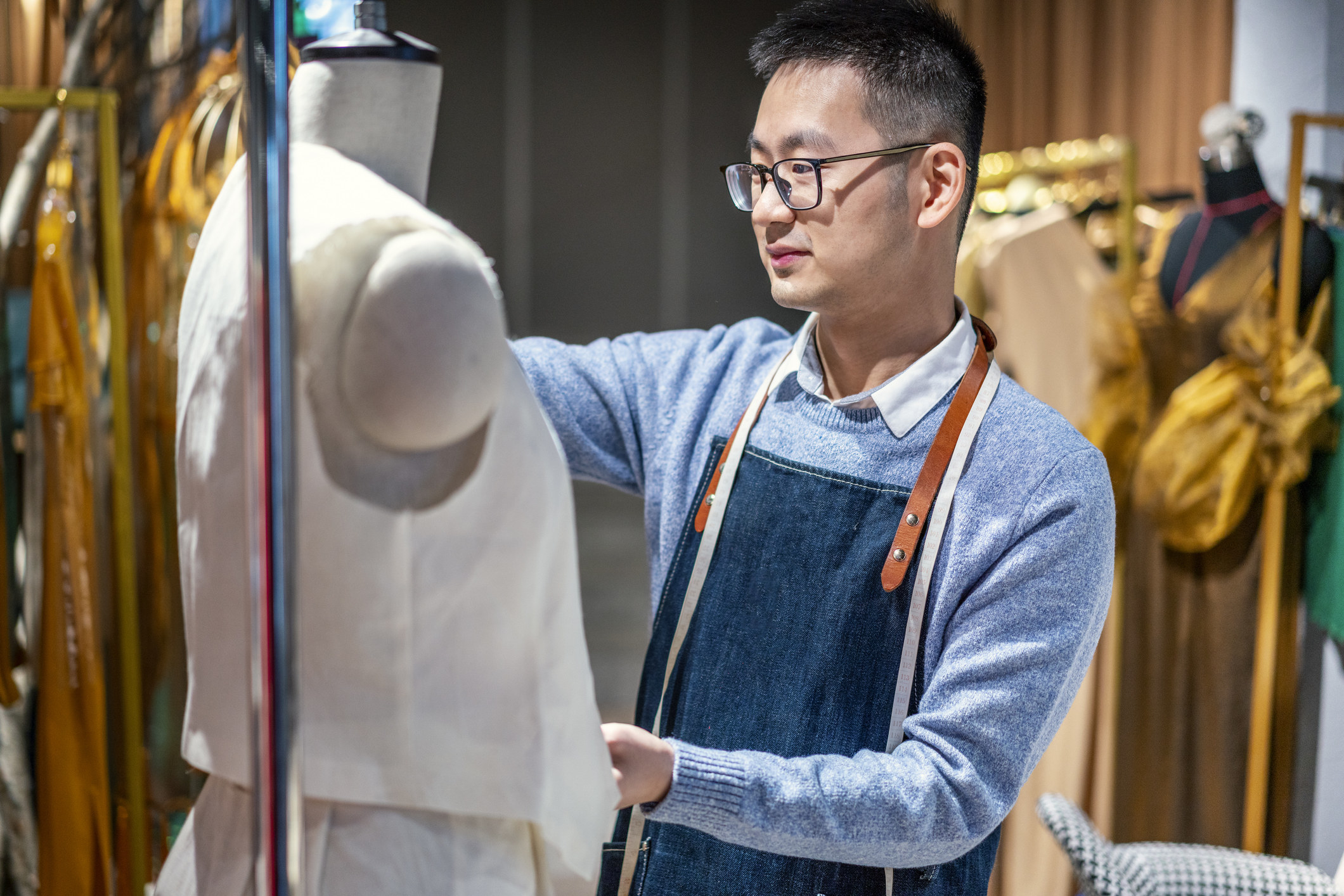 Man fitting a garment on a dress form