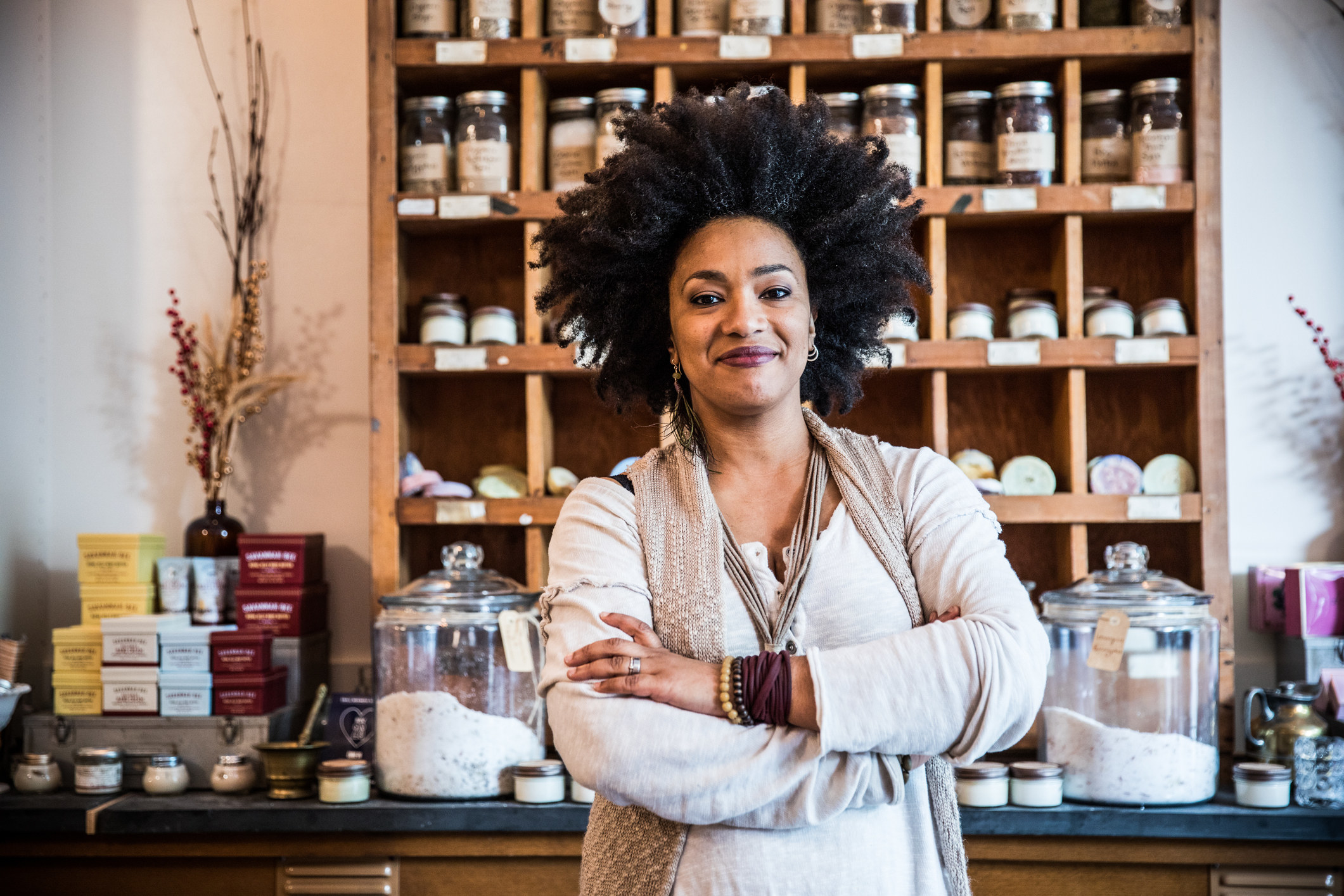 a woman standing in front of a selection of homemade beauty products