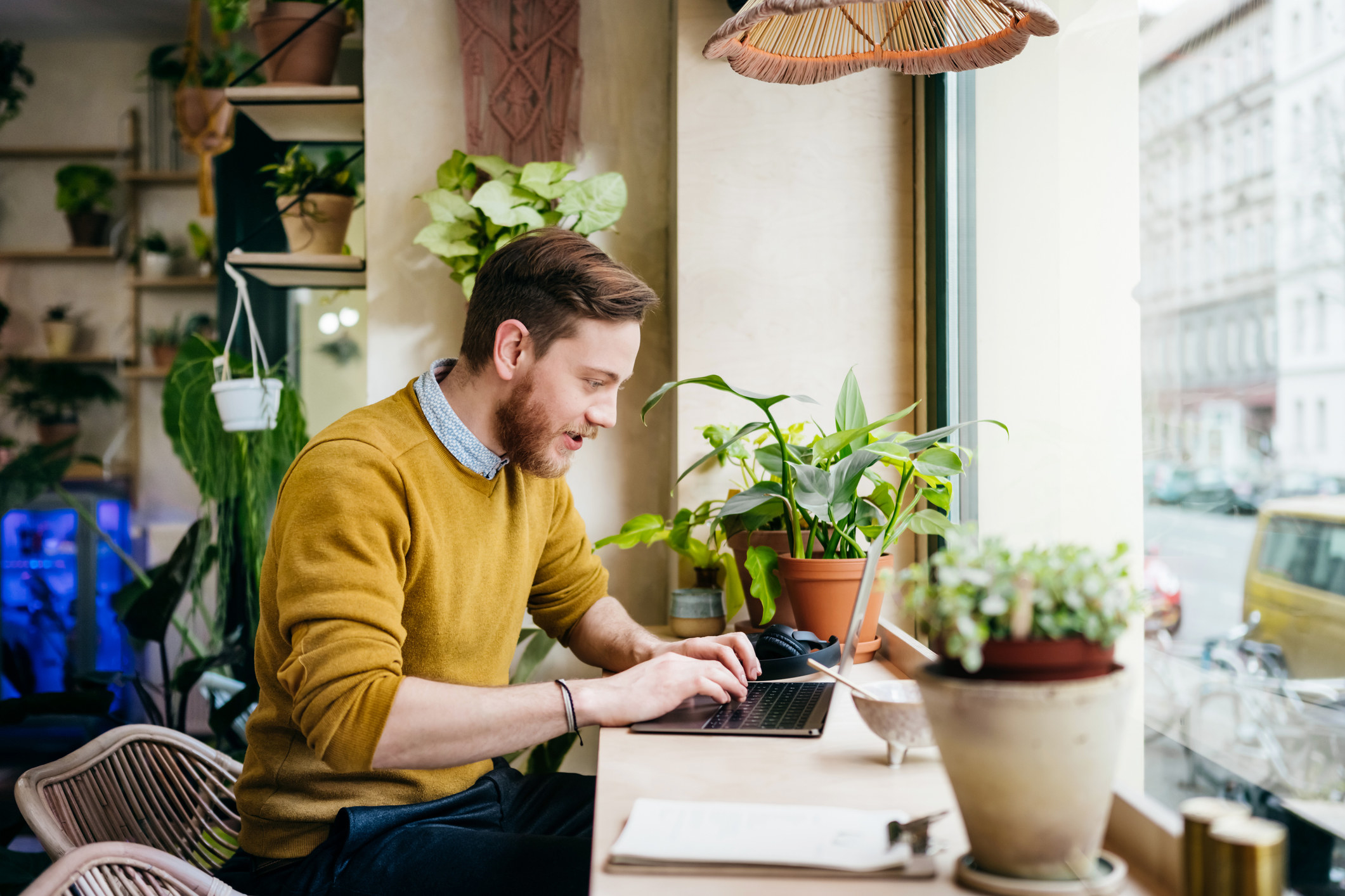 Young man sitting in cafe using laptop