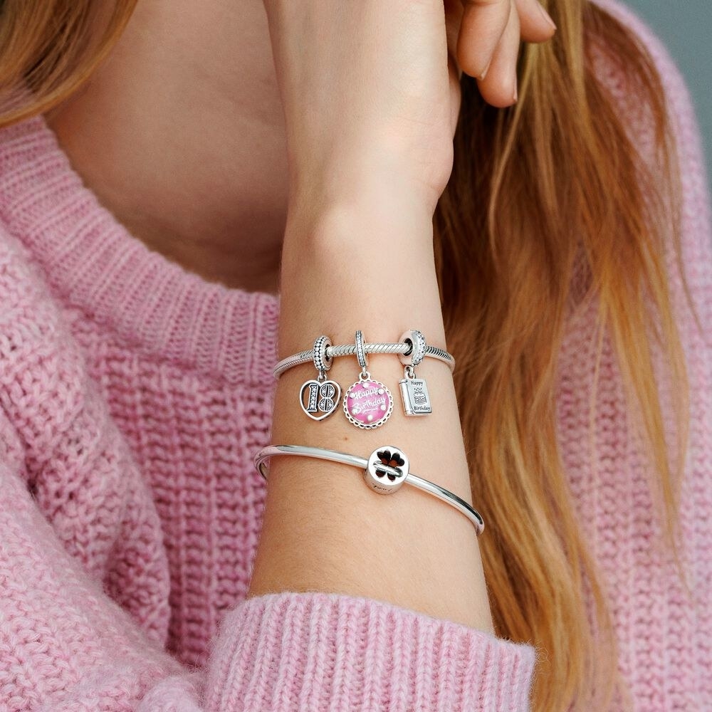 A close-up of a woman's wrist wearing Pandora bracelets