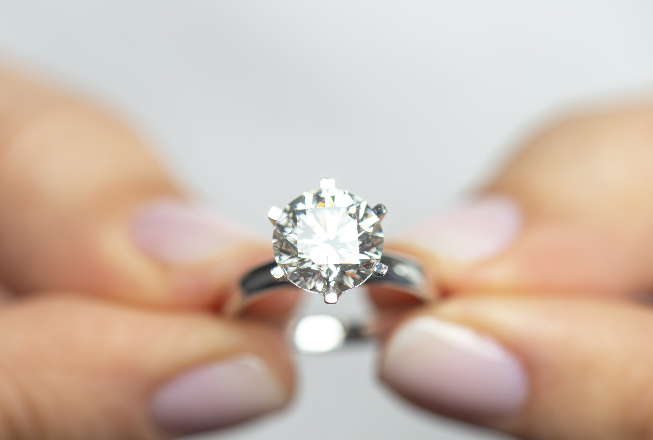 A stock image of a person holding a diamond ring