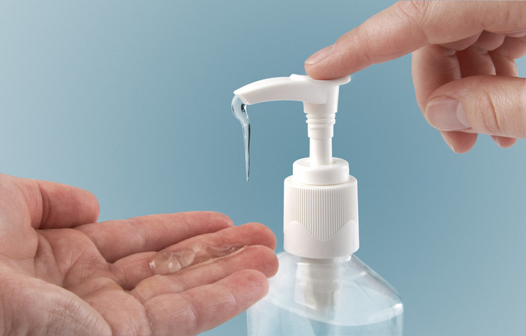 A stock image of hands pumping out hand sanitizer