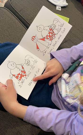 reviewer's child reading a story with a human and cat illustrations