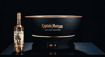 Zoom-in on Captain Morgan Super Bowl Punch Bowl next to bottle of Captain Morgan