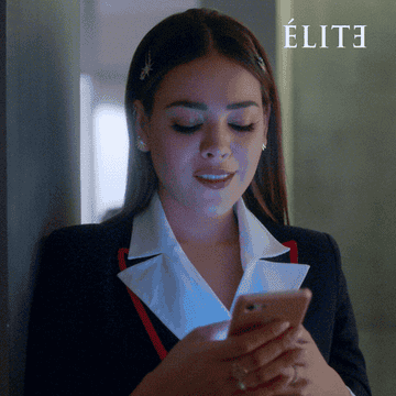 person smiling at their phone and then looking at it in disgust in &quot;elite&quot;