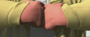 A man pulling his street clothes aside to reveal his superhero suit underneath