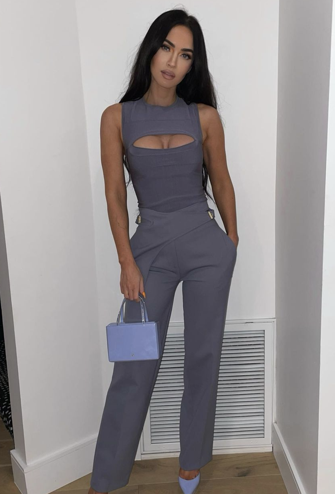 Megan wearing a pantsuit with a cutout on the top with a matching box purse and heels