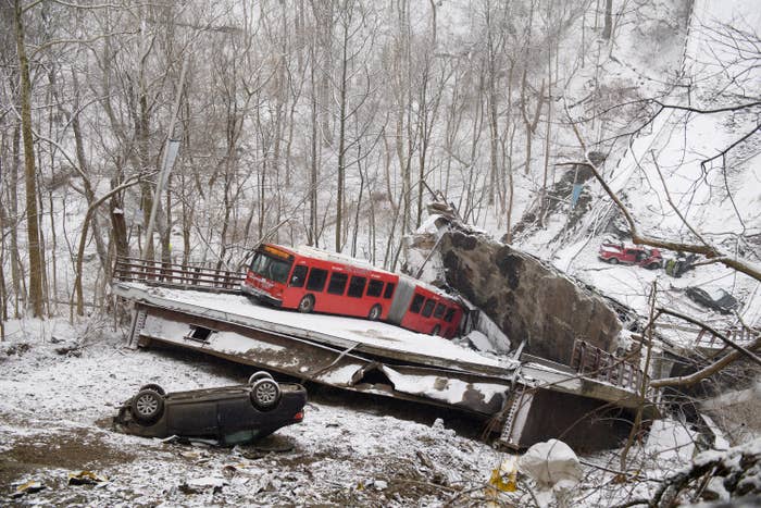 A commuter bus and upside down car are seen in the wreckage of the bridge collapse amid snow