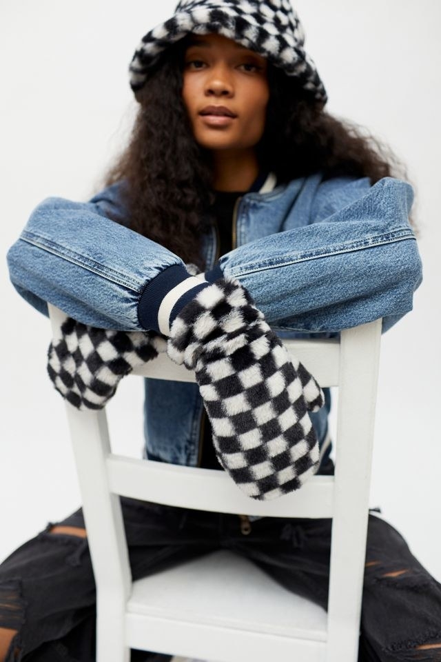 a model wearing the white and black checkered mittens
