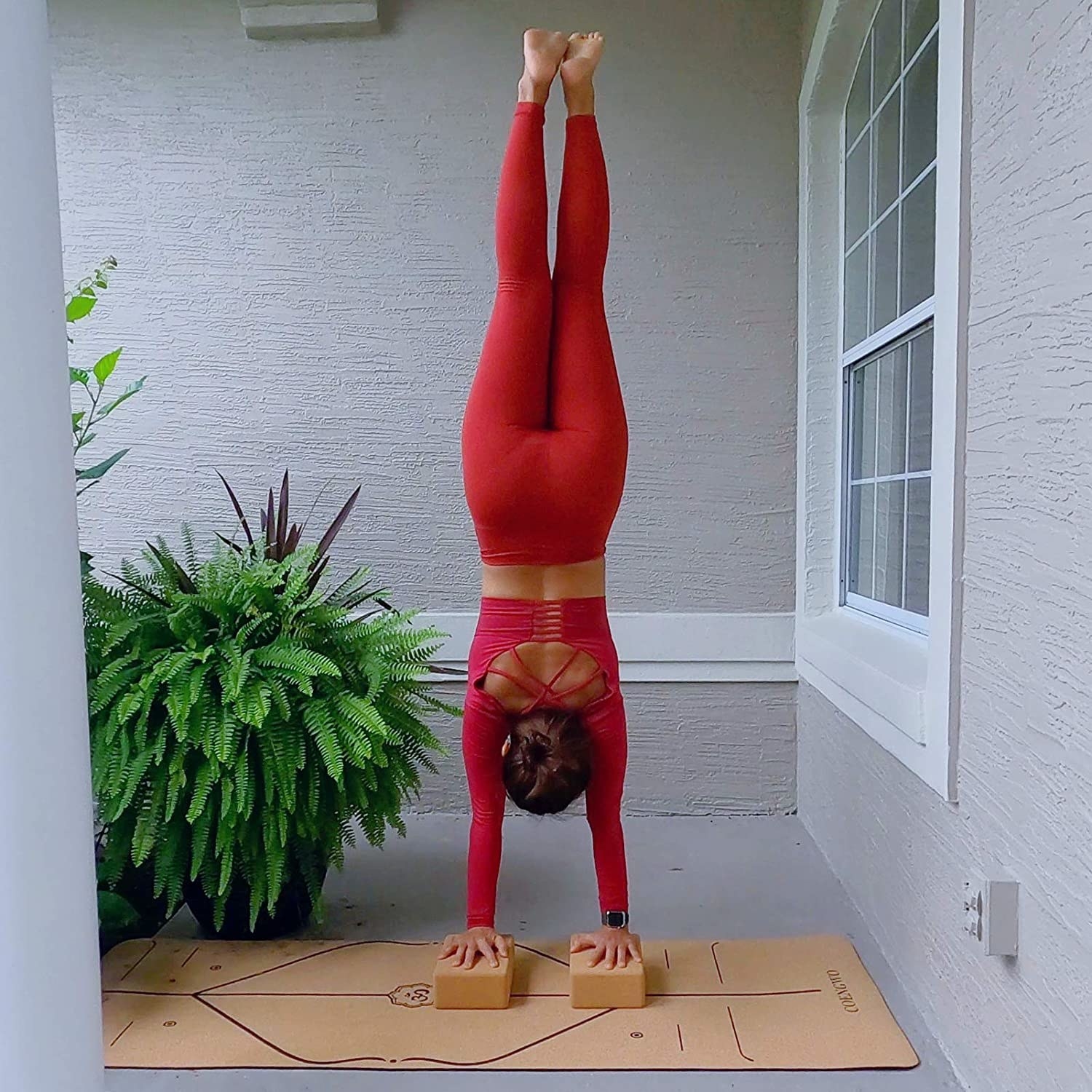 A person doing a handstand on two cork blocks