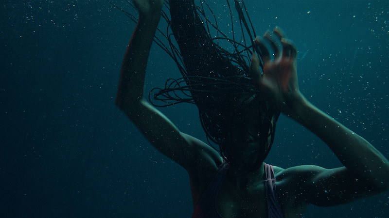 A shadowy photo of a person either against a nighttime sky or underwater