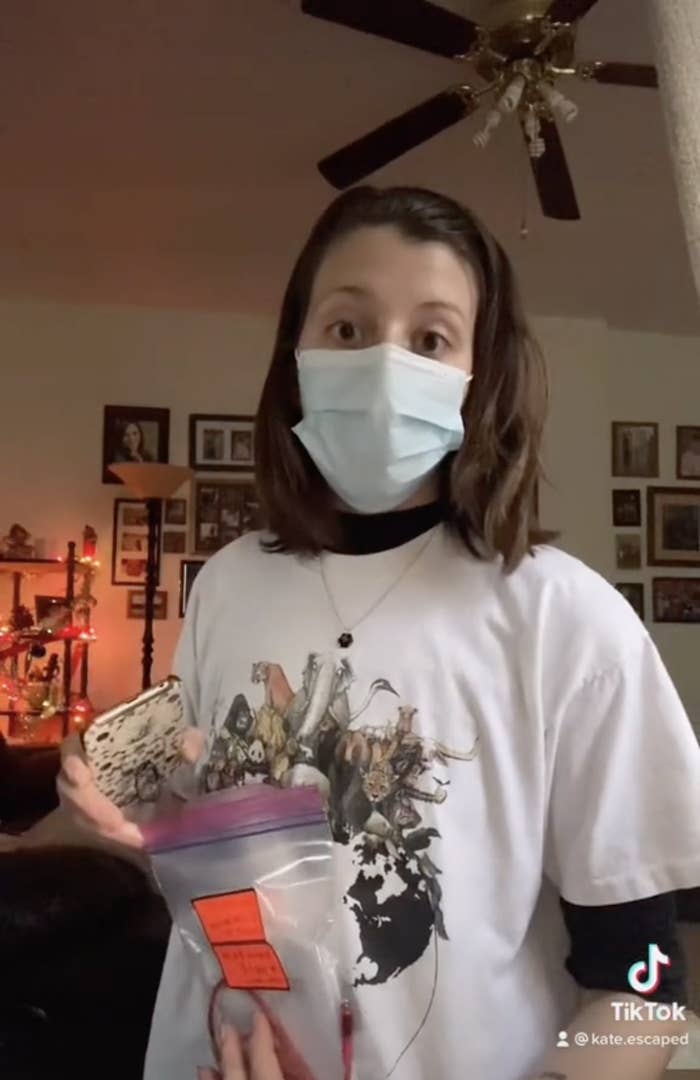 Screengrabs of a TikTok by user Kate.escaped where she is wearing a facial mask and holding a plastic bag with a sticker on the outside