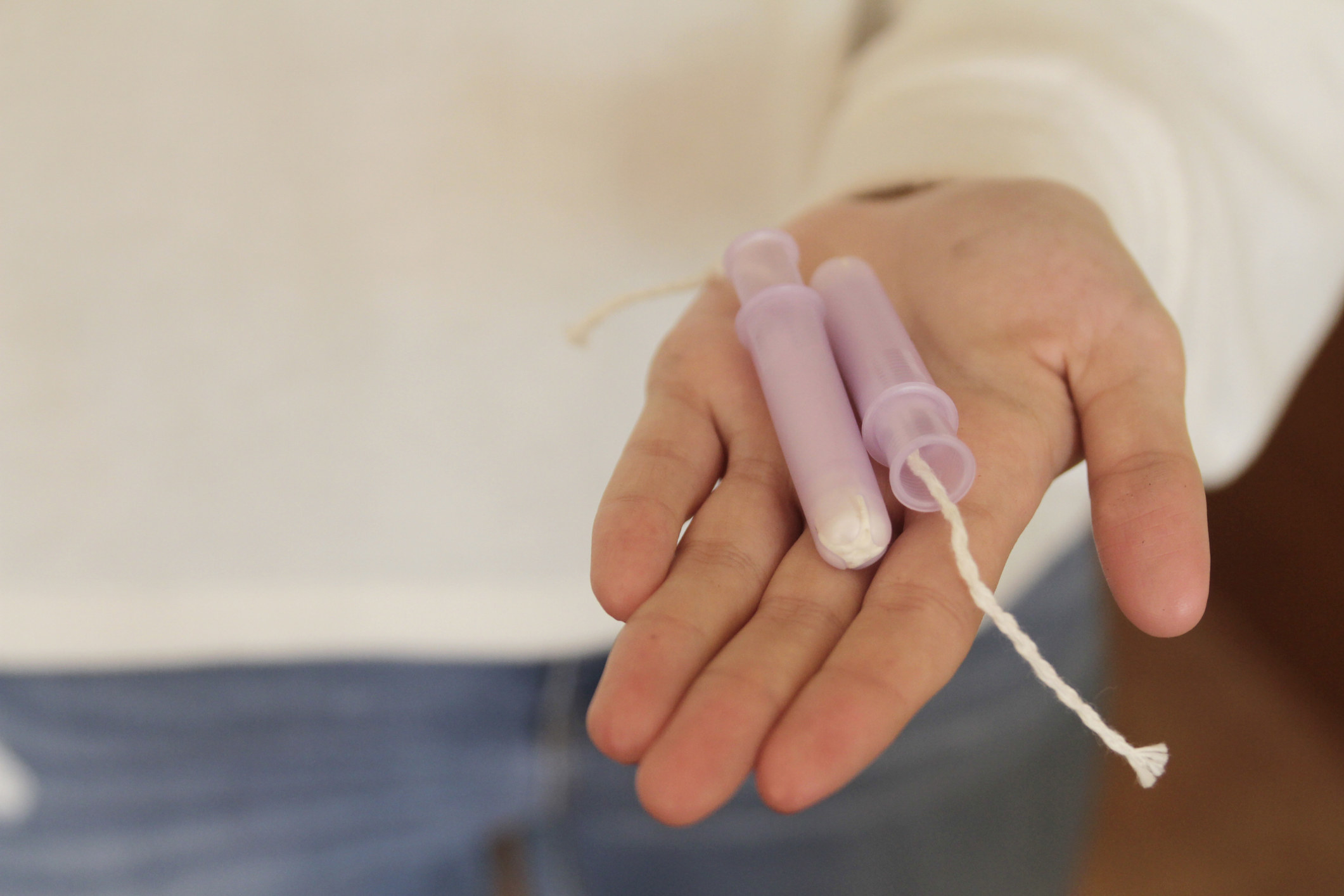 A woman holding tampons in her hand