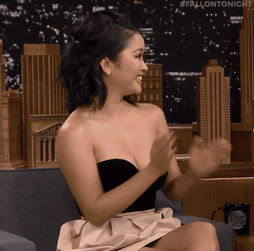 Lana smiling and clapping as she sits during a late-night tv interview