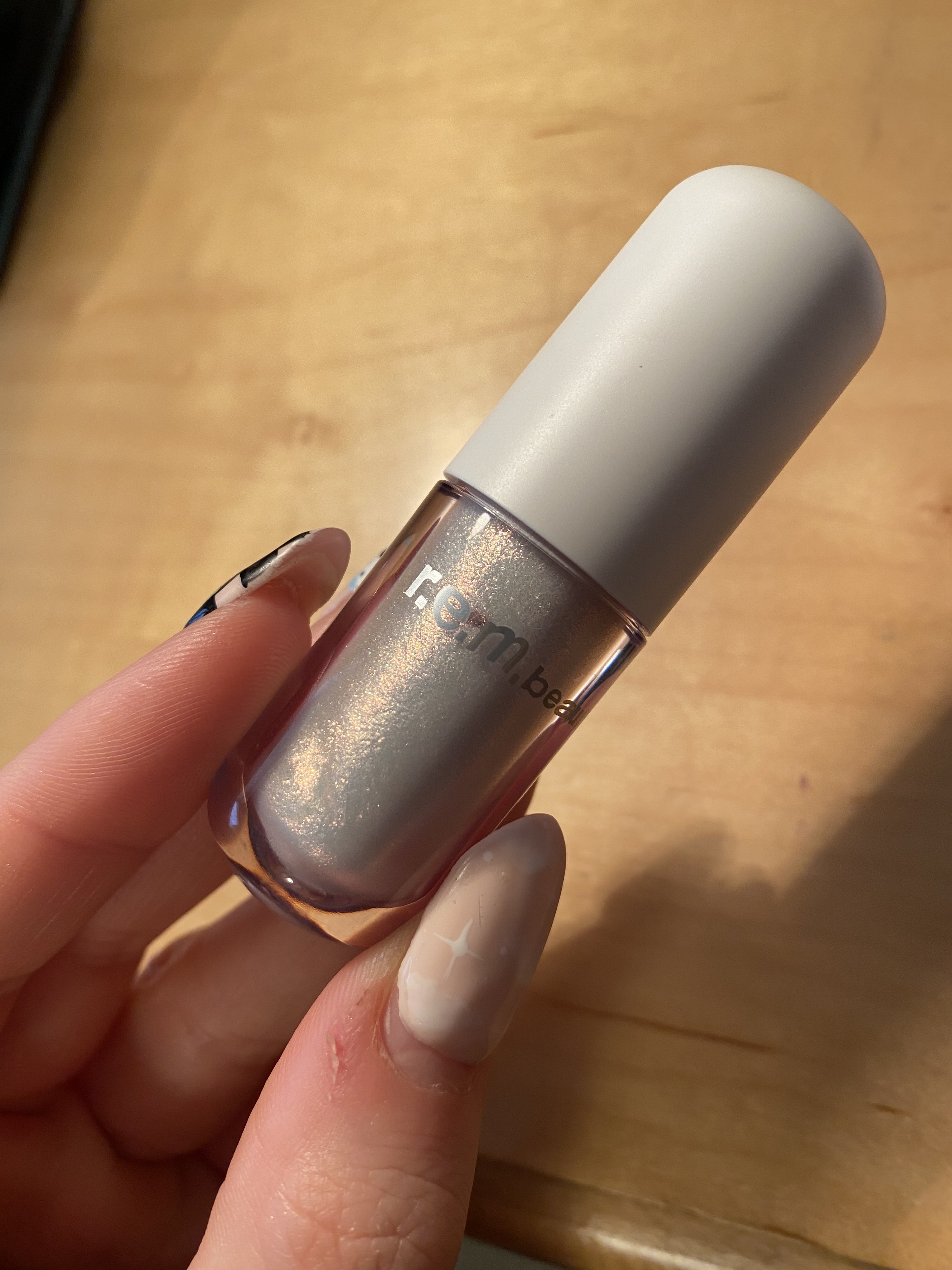 An up-close shot of the liquid eyeshadow being held by the author&#x27;s fingers