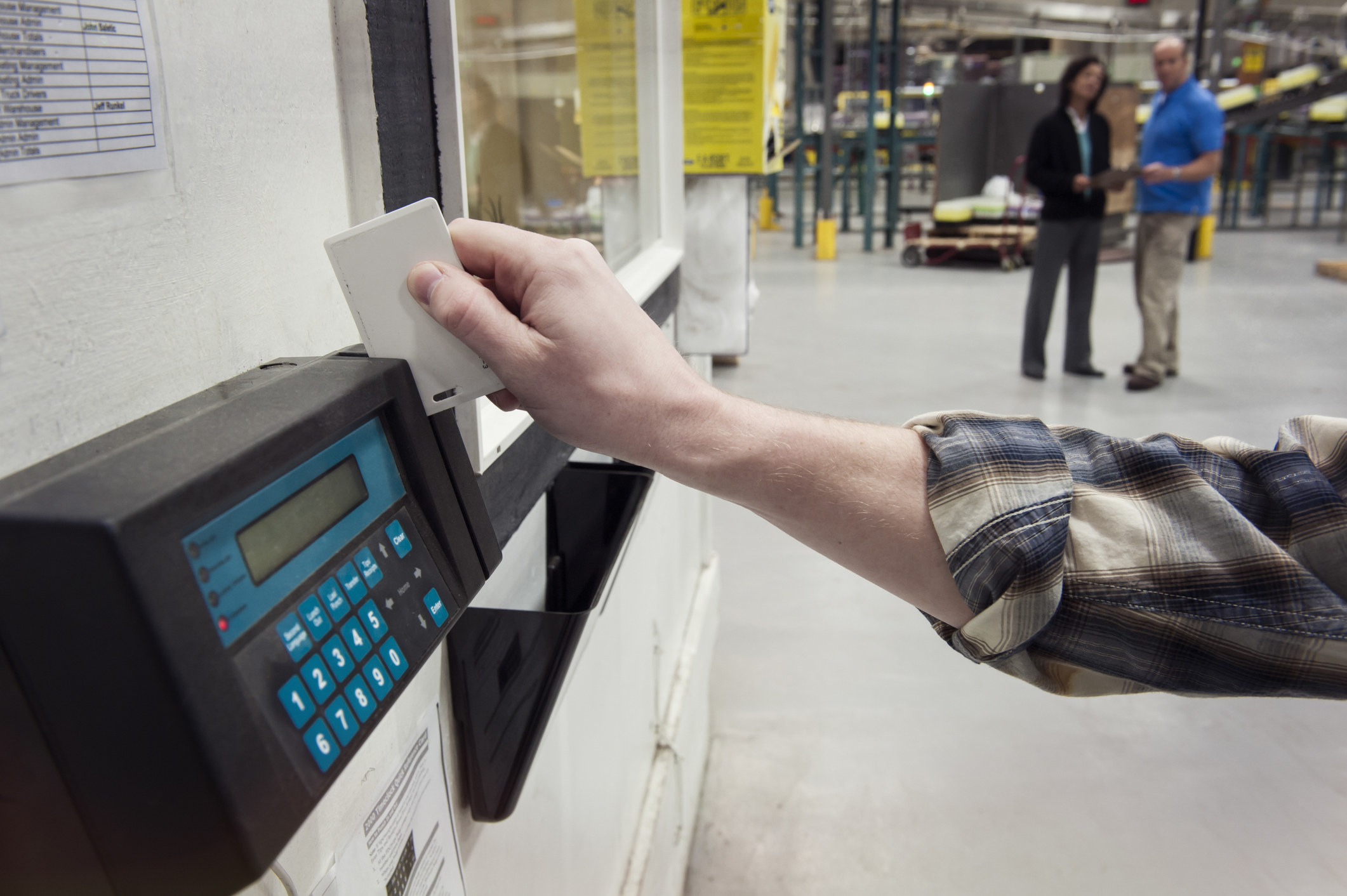 A person swiping a keycard to clock in