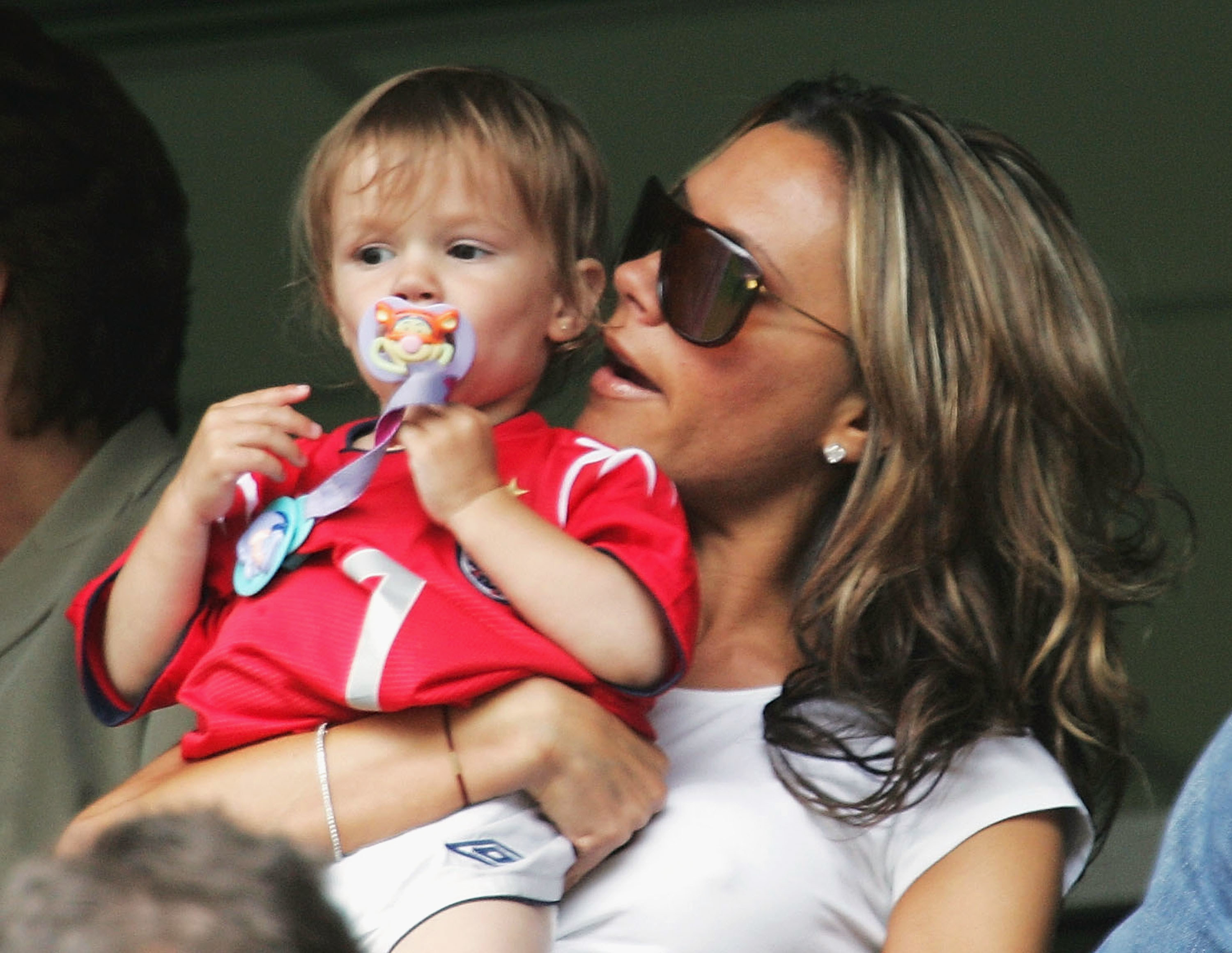 Victoria Beckham holding a young Romeo Beckham