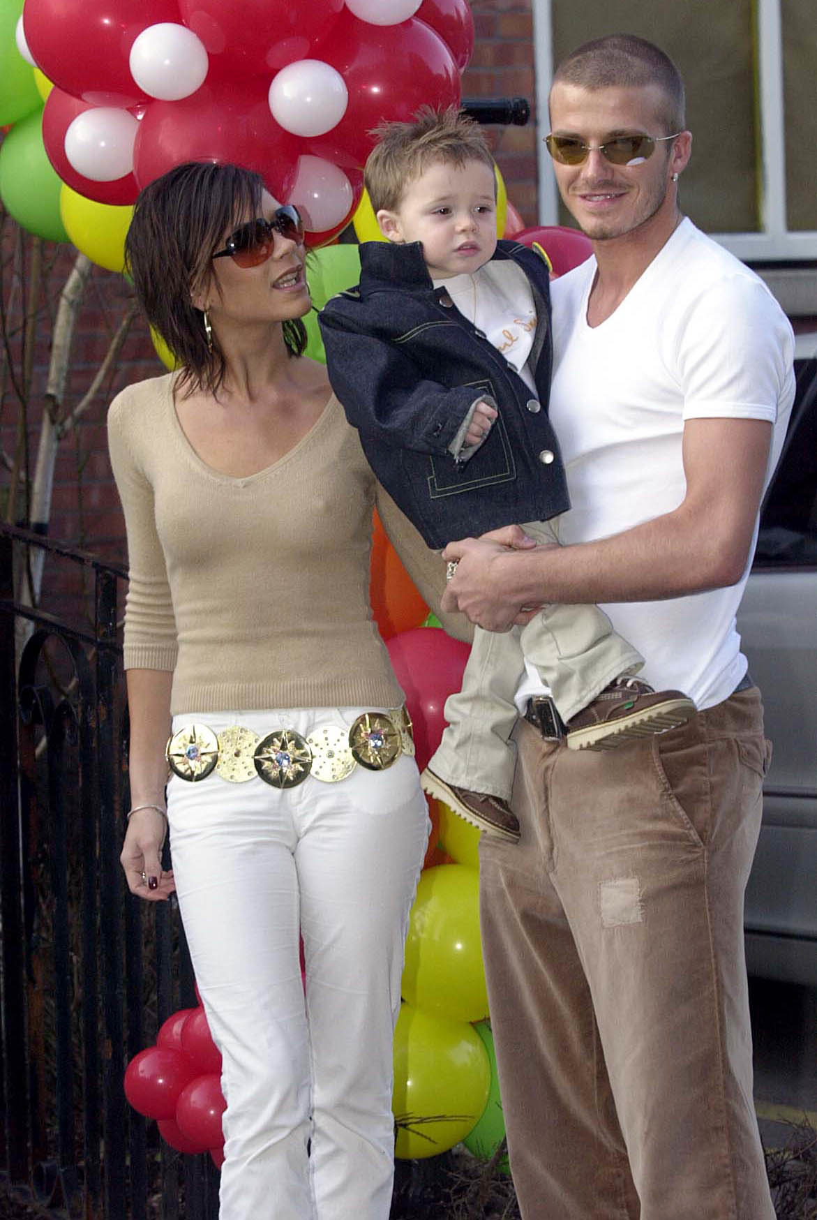 David and Victoria Beckham holding a young Brooklyn Beckham