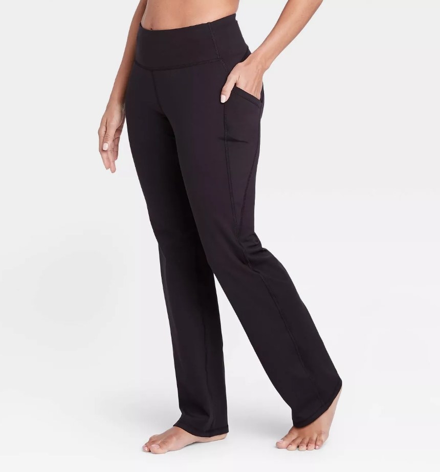 A model wearing a pair of high-rise straight leg yoga pants in black