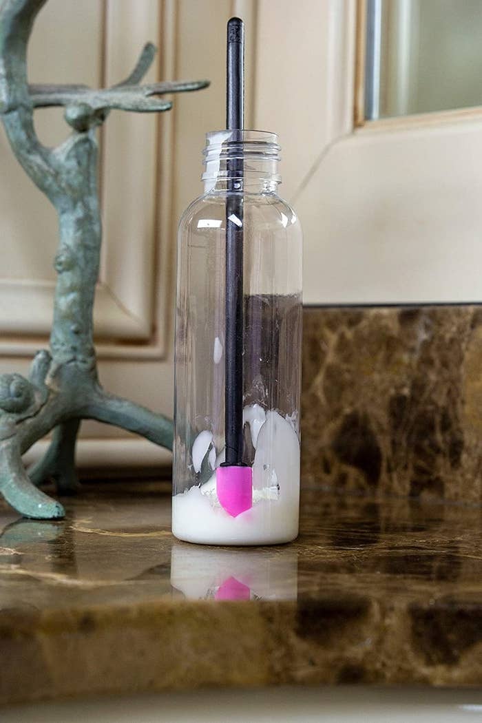 A spatula in a bottle of lotion on a counter